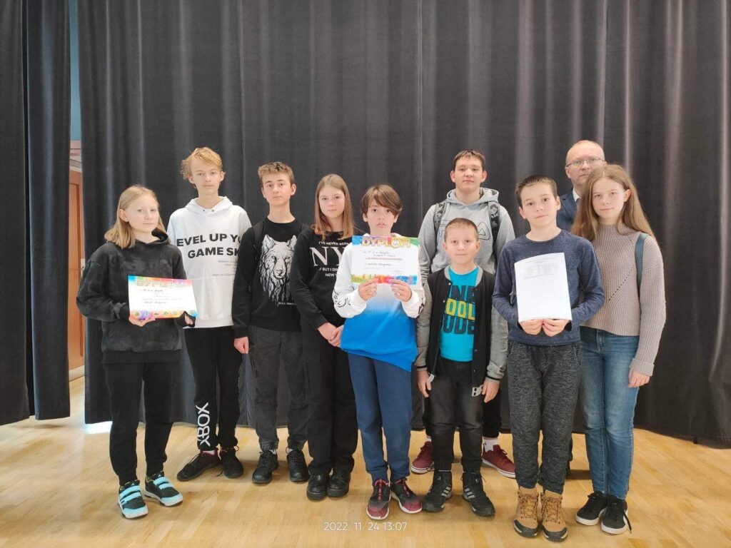 Stojące dzieci i trzymające dyplomy na zawodach w szachy